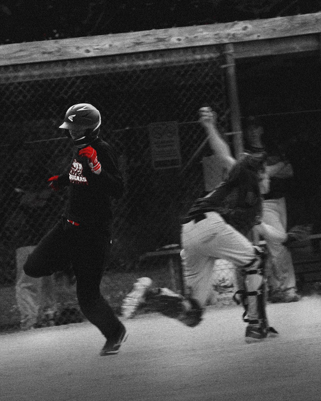 Baseball players moving through a play near the dugout.